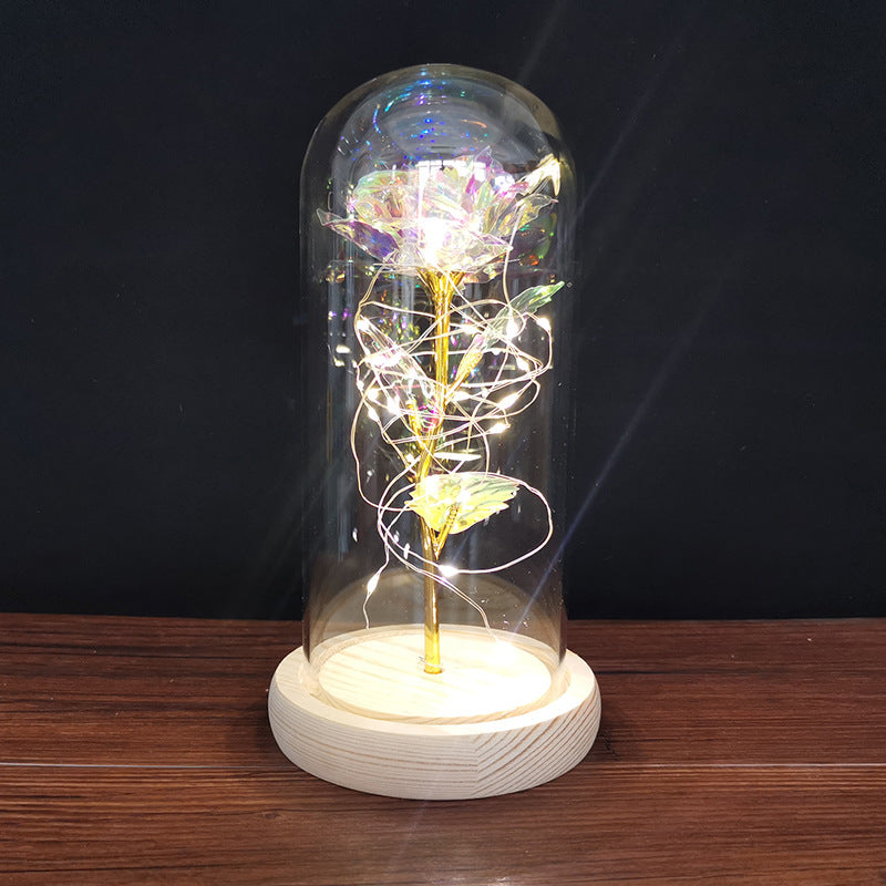 Iridescent eternal rose under glass on a wooden base
