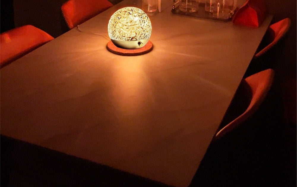 La Marée glowing warm gold on a dining table at night